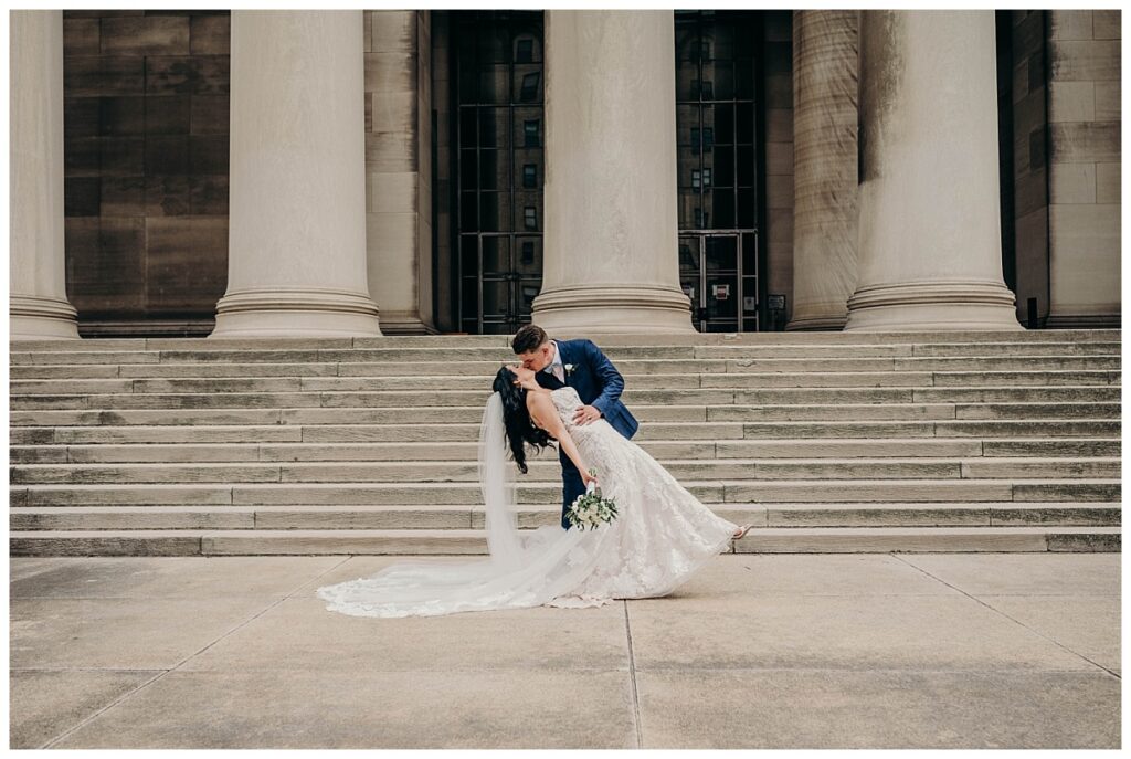 ride and groom sharing a romantic embrace at the Mellon Institute, framed by the venue’s luxurious setting and their elegant outfits.